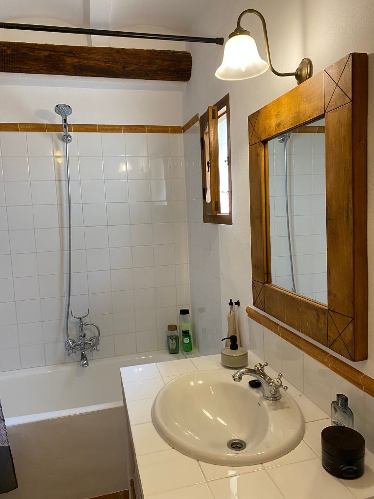 Badkamer met ligbad, wastafel en toilet